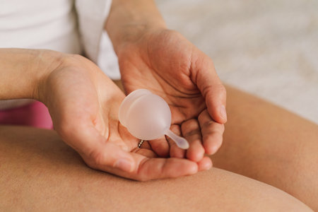 A woman in underwear holds a menstrual cup in her handsの写真素材