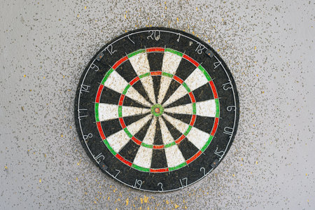 Use classic professional sisal dart board on gray wooden background.