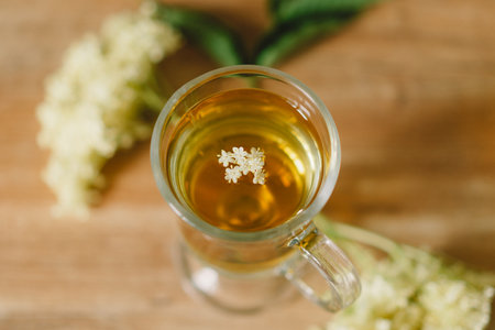 Elderflower Tea in a Glass Mug on a Rustic Wooden Table During Daytimeの写真素材