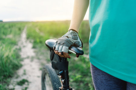 Closeup Of A Persons Hand On A Bike Seat During An Outdoor Rideの写真素材