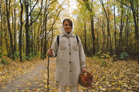 Woman Enjoying Autumn Walk in Forestの写真素材