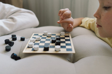 Teenage Girl and Boy Playing Board Game checkers In Living Room