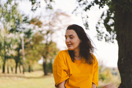 A woman enjoys a sunny day outdoorsの写真素材
