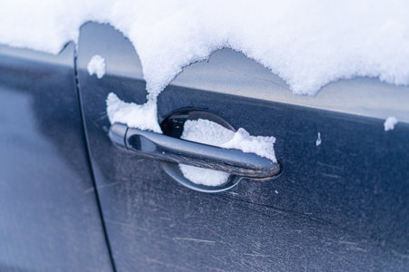 Snow covers the car door handleの写真素材
