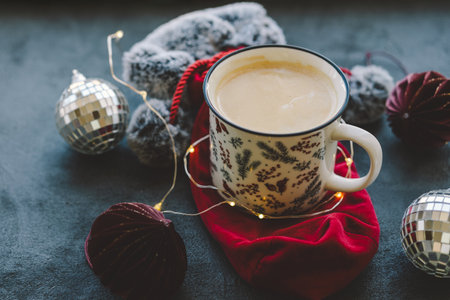 Cozy winter setting with drink, holiday gifts, and festive decorationsの写真素材