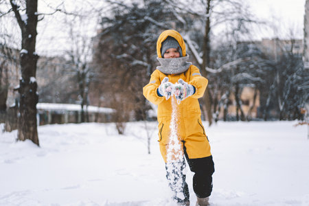 A joyful child playing in fresh snow during winters frosty embraceの写真素材