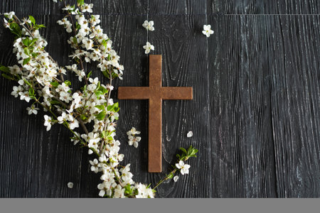 Cross with flowers on a wooden background with the inscription Christ is Risenの写真素材