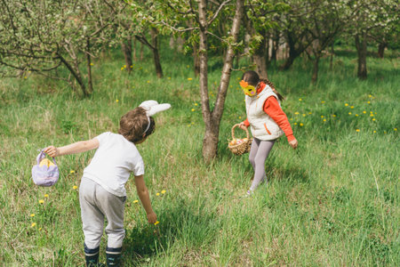 Two children hunt for Easter eggs in a spring garden. Easter traditionの写真素材