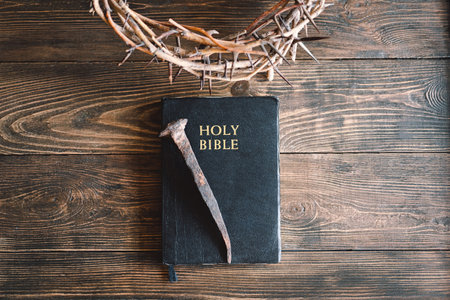 Crown thorns and holy bible or book on a wood background
