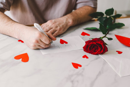 Happy Valentines Day and romantic gesture. A man writes a valentine.の写真素材