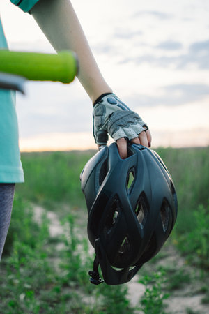 Woman Holding Bike Helmet and Glasses on a Dirt Pathの写真素材