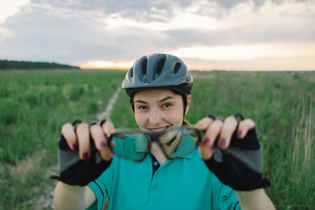 Woman Wearing Cycling Glasses and Helmet in Fieldの写真素材
