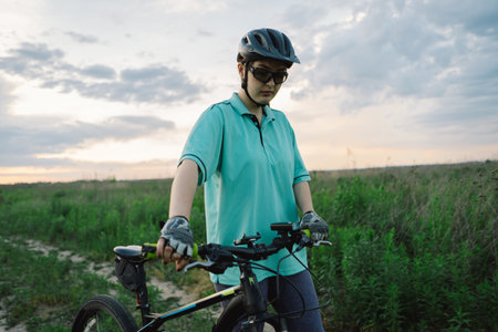 Woman Riding a Mountain Bike on a Dirt Path Near Suburbiaの写真素材