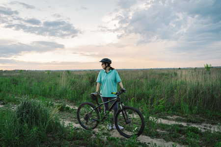 Woman Riding a Mountain Bike on a Dirt Path Near Suburbiaの写真素材