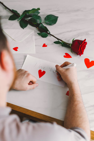 Happy Valentines Day and romantic gesture. A man writes a valentine.の写真素材
