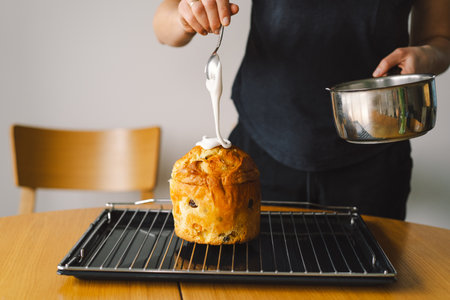 Baking a festive easter panettone with icing on a kitchen countertop during springtime preparationsの写真素材