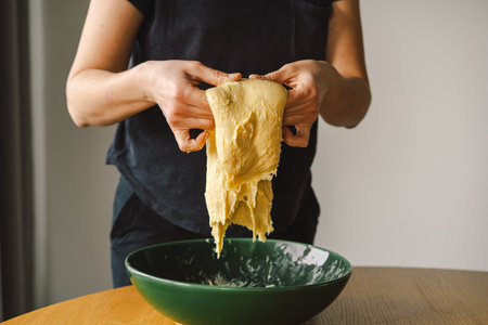 Woman prepares dough for bakingの写真素材