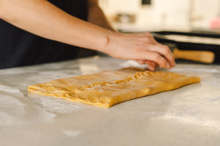 Woman prepares dough for bakingの写真素材
