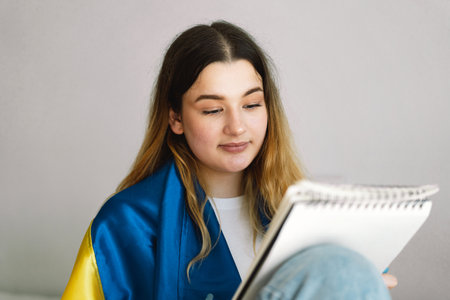 A Ukrainian teenage girl is drawing or doing homeworkの写真素材