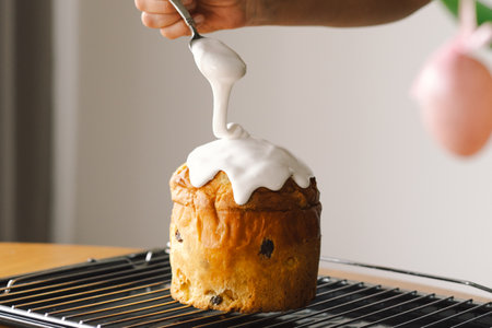 Baking a festive easter panettone with icing on a kitchen countertop during springtime preparationsの写真素材
