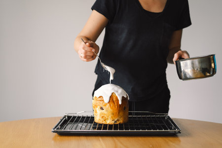Baking a festive easter panettone with icing on a kitchen countertop during springtime preparationsの写真素材
