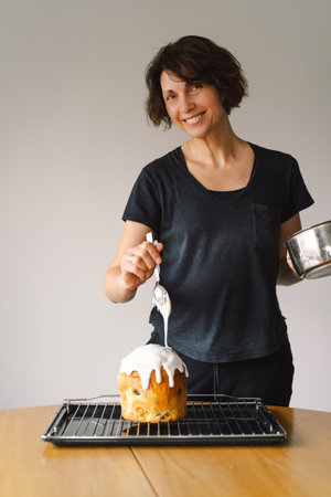 Baking a festive easter panettone with icing on a kitchen countertop during springtime preparationsの写真素材