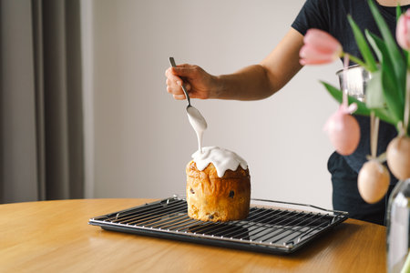 Baking a festive easter panettone with icing on a kitchen countertop during springtime preparationsの写真素材