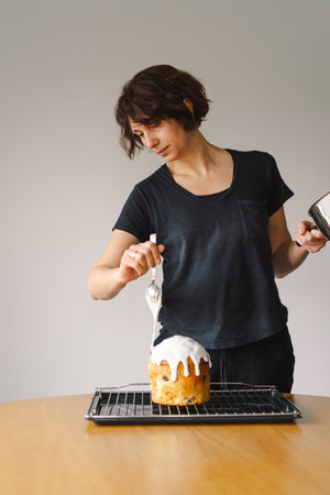Baking a festive easter panettone with icing on a kitchen countertop during springtime preparationsの写真素材