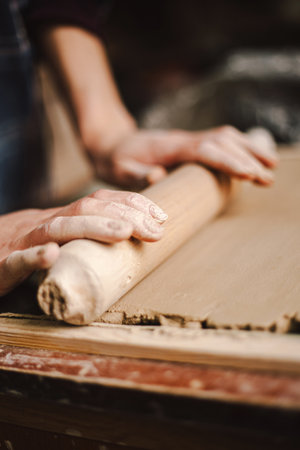 Hands skillfully shape a clay pot in a pottery studioの写真素材