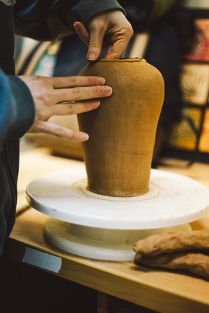 Hands skillfully shape a clay pot in a pottery studioの写真素材