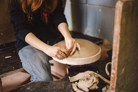 Hands skillfully shape a clay pot in a pottery studioの写真素材