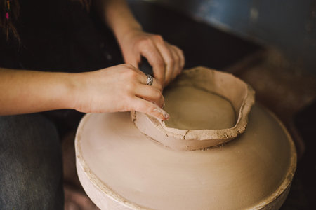 Hands skillfully shape a clay pot in a pottery studioの写真素材