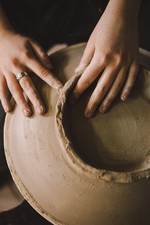 Hands skillfully shape a clay pot in a pottery studioの写真素材