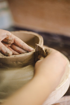 Hands skillfully shape a clay pot in a pottery studioの写真素材