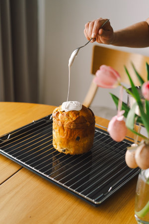 Baking a festive easter panettone with icing on a kitchen countertop during springtime preparationsの写真素材