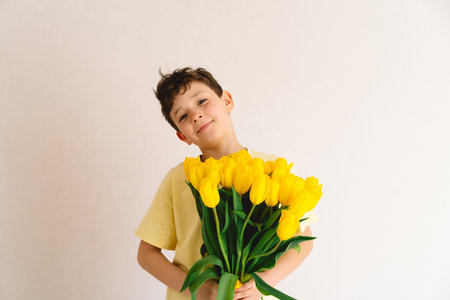 Child joyfully holding a bouquet of vibrant yellow tulipsの写真素材
