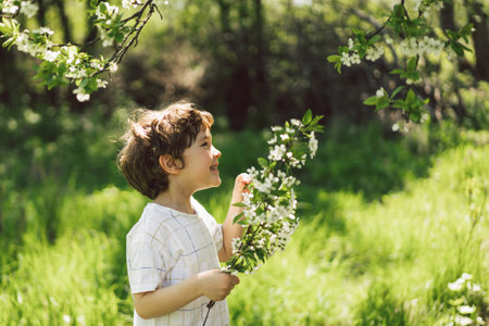 Happy little boy walking in spring garden.の写真素材