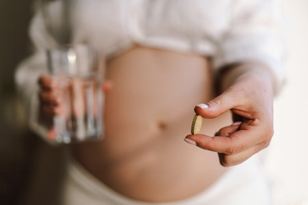 Pregnant young woman holding vitaminsの写真素材