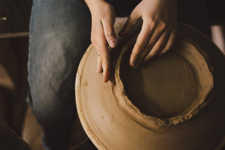 Hands skillfully shape a clay pot in a pottery studioの写真素材