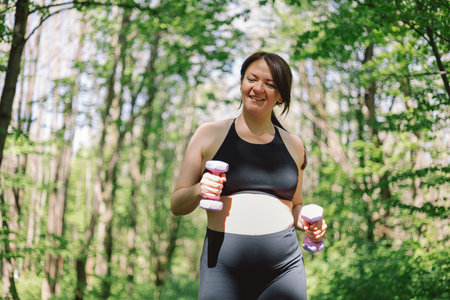 Pregnant woman doing fitness outdoors.の写真素材