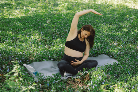 Pregnant woman doing fitness outdoors.の写真素材
