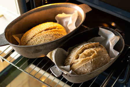 Freshly baked loaves of bread cooling in an oven just before being servedの写真素材