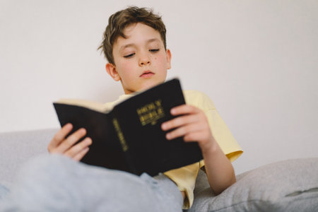 A boy is reading the holy bible.の写真素材