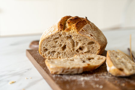 Freshly baked sourdough bread with a jar of starter and rustic cloth