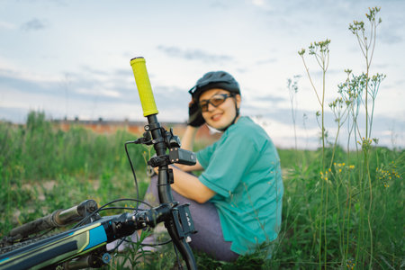 Woman Rests Beside Her Bicycle in a Fieldの写真素材