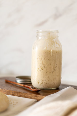 Baking sourdough bread in a cozy kitchen with fresh dough, starter preparationの写真素材