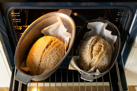 Freshly baked loaves of bread cooling in an oven just before being servedの写真素材