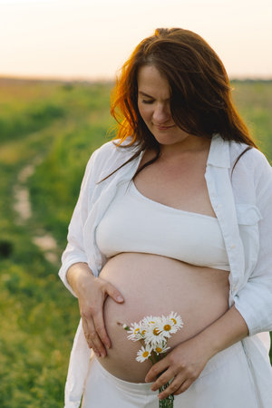 Pregnant woman in a field. Expecting joyful moments