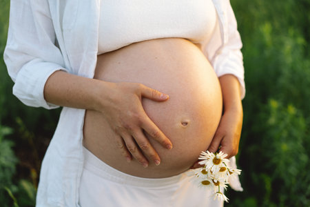 Pregnant woman in a field. Expecting joyful momentsの写真素材