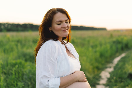 Pregnant woman in a field. Expecting joyful moments